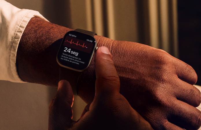 Uma pessoa pressiona a Digital Crown no Apple Watch Series 11 para medir a saúde do coração no app ECG