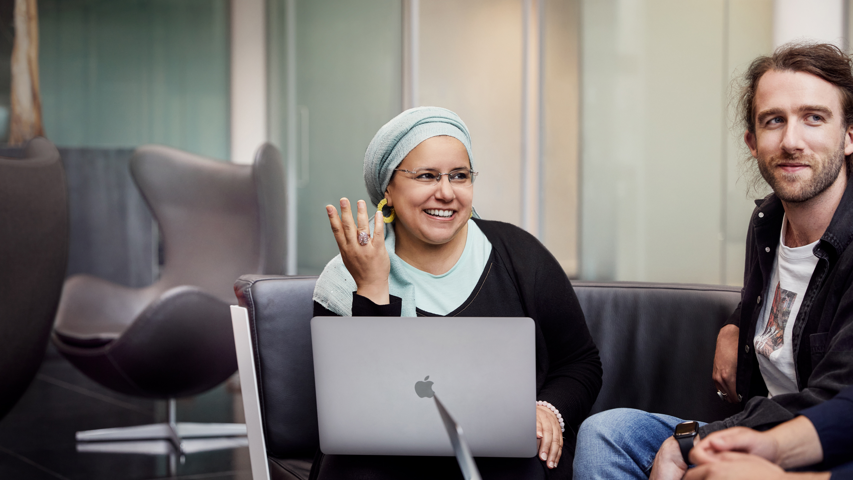 Zaměstnanci Apple Cork sedí pohromadě a spolupracují.