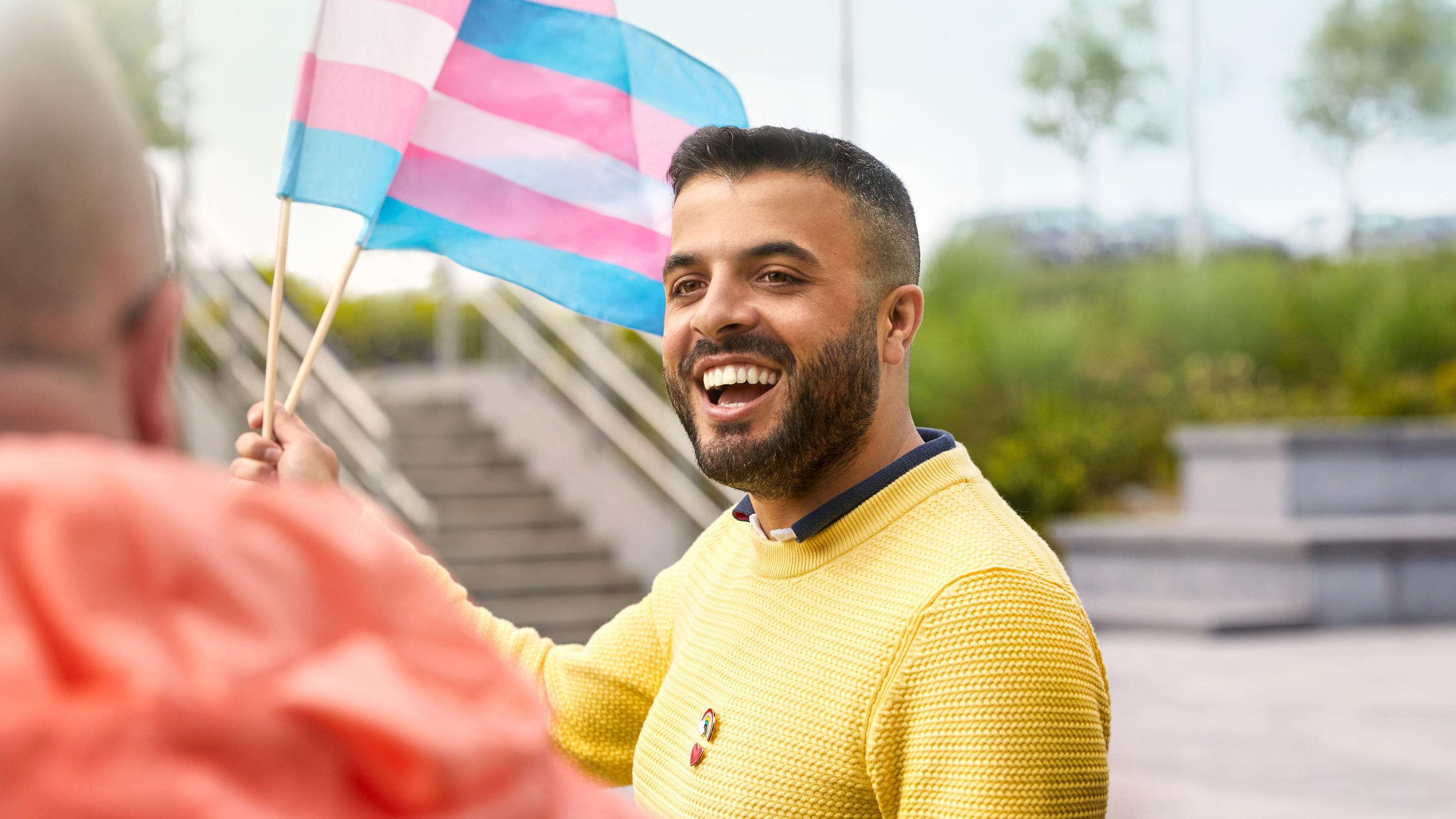 Zaměstnanec Apple Cork mává vlajkou transgender komunity.