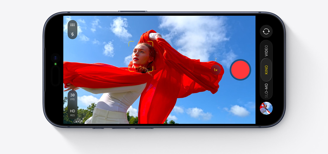 Ein iPhone Display zeigt den Kinomodus, der eine tanzende Person mit einem fließenden roten Schal im Freien aufnimmt