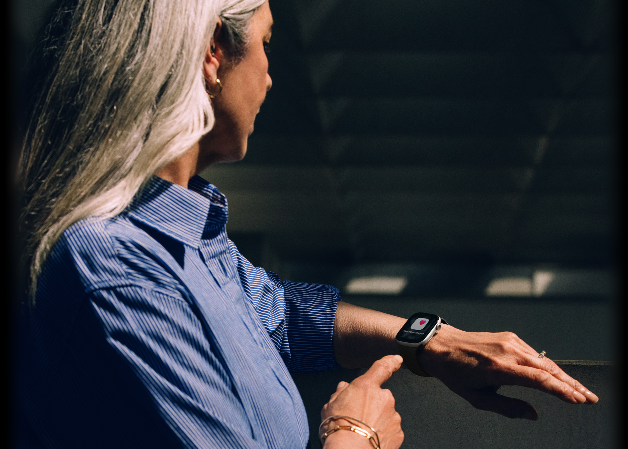 Apple Watch Series 11’deki hipertansiyon bildirimini okuyan bir kişi
